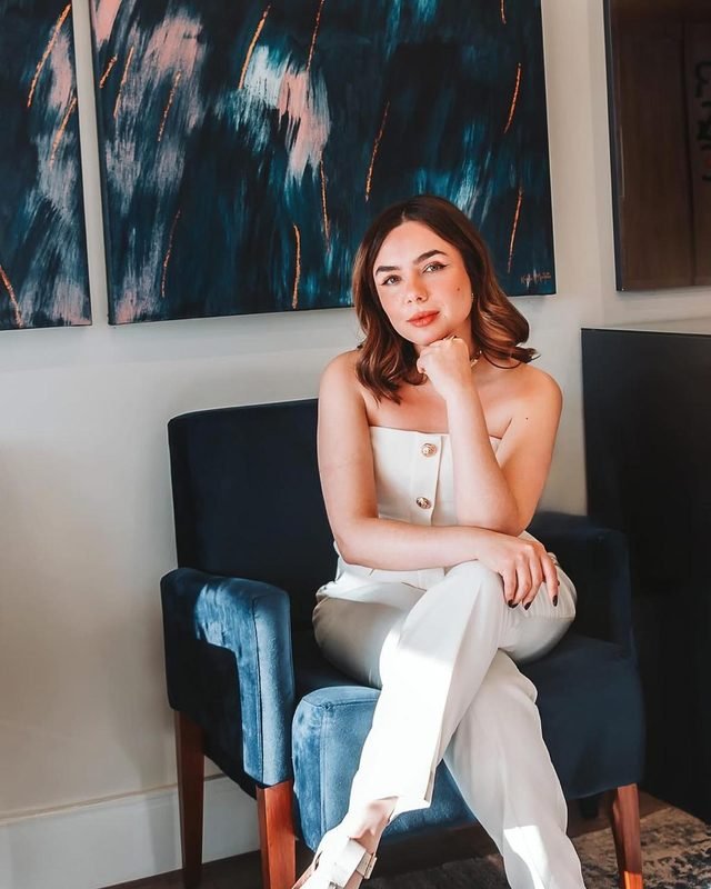 Ailsany Neline Menezes de Morais, advogada, sentada em poltrona azul